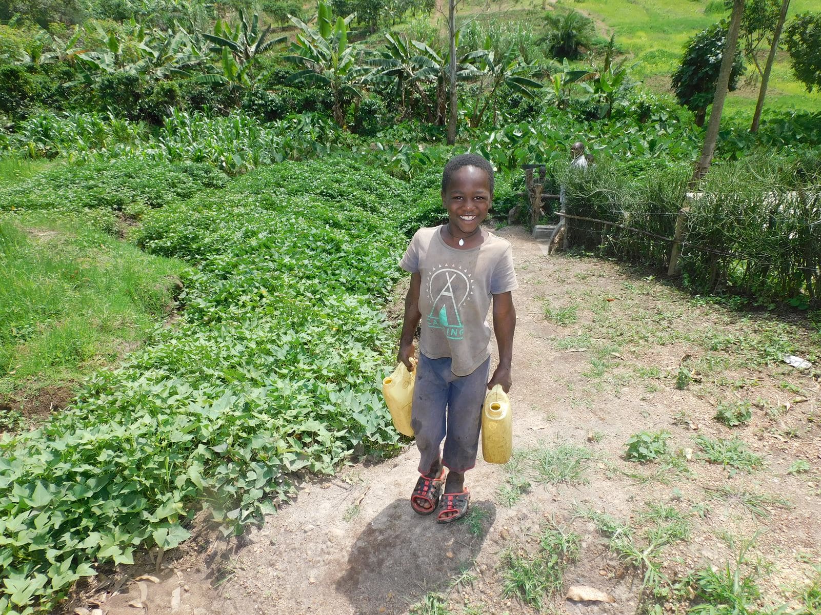 Ben Mwebembezi,5, fetching water from Kitojo Primary School Water Source