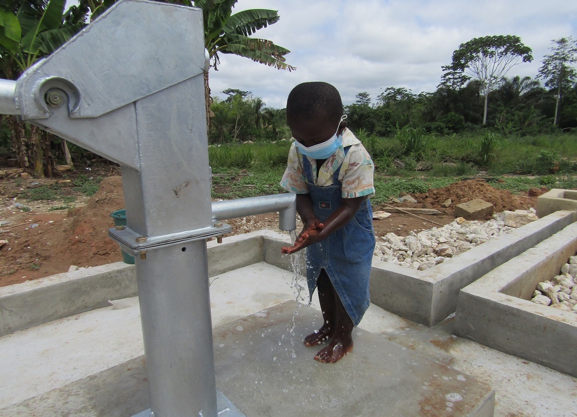 Young girl practices handwashing at Aflaso Twapease well