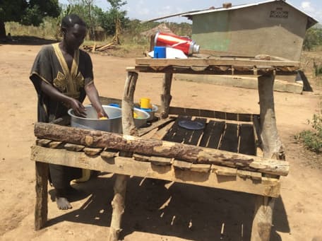 Susan washing her utensils and using drying rack Ayito village Amach SubCounty Lira district northern Uganda